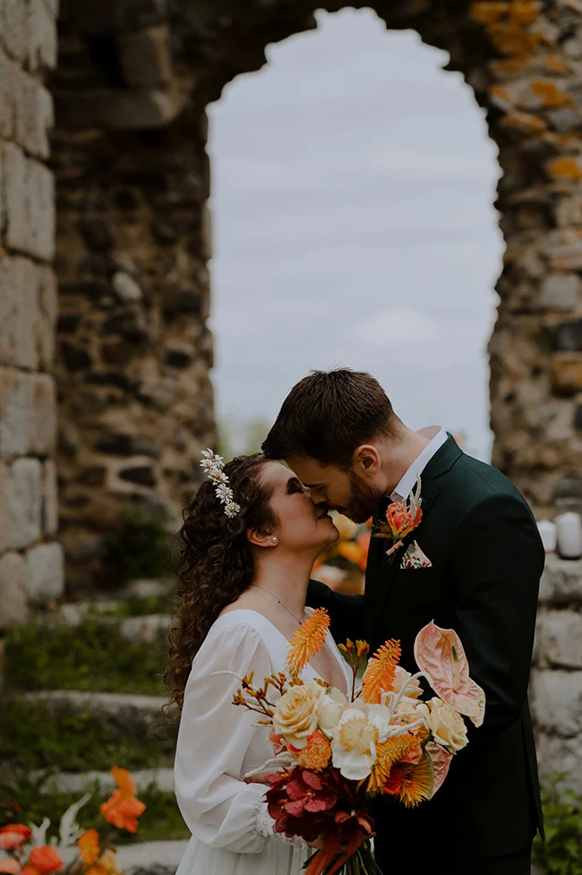 Un couple romantique se baigne dans l'ambiance intime d'un elopement au cœur des ruines historiques.