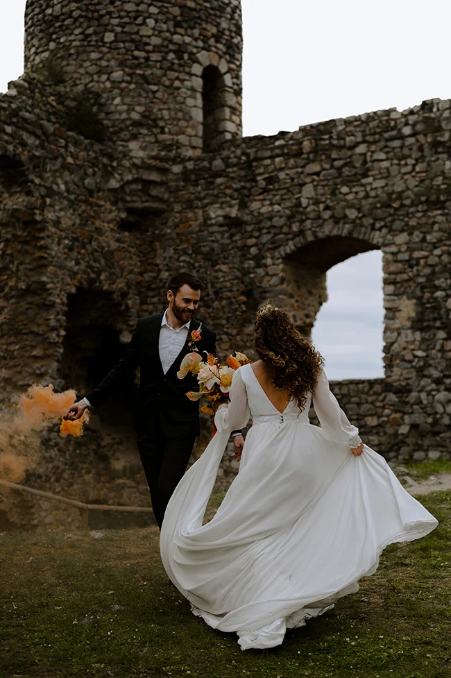 Un couple romantique se débarque dans les ruines, célébrant leur amour à travers des couleurs chaudes et des éclats de fumette.