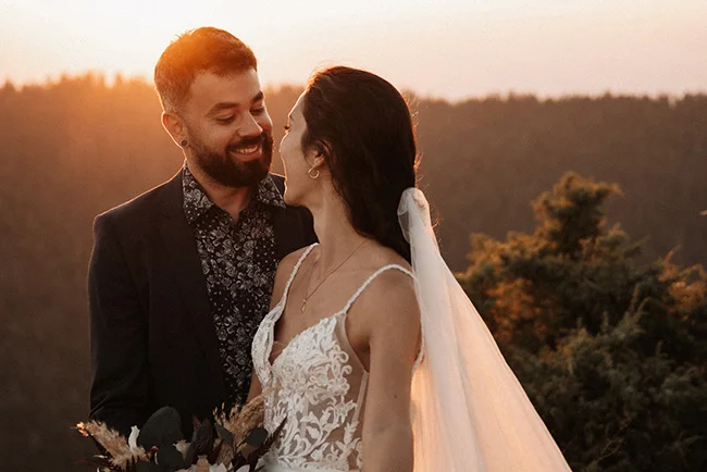 Un couple heureux se regarde l'un l'autre au coucher de soleil, entouré de la beauté naturelle du Parc National du Vercors.