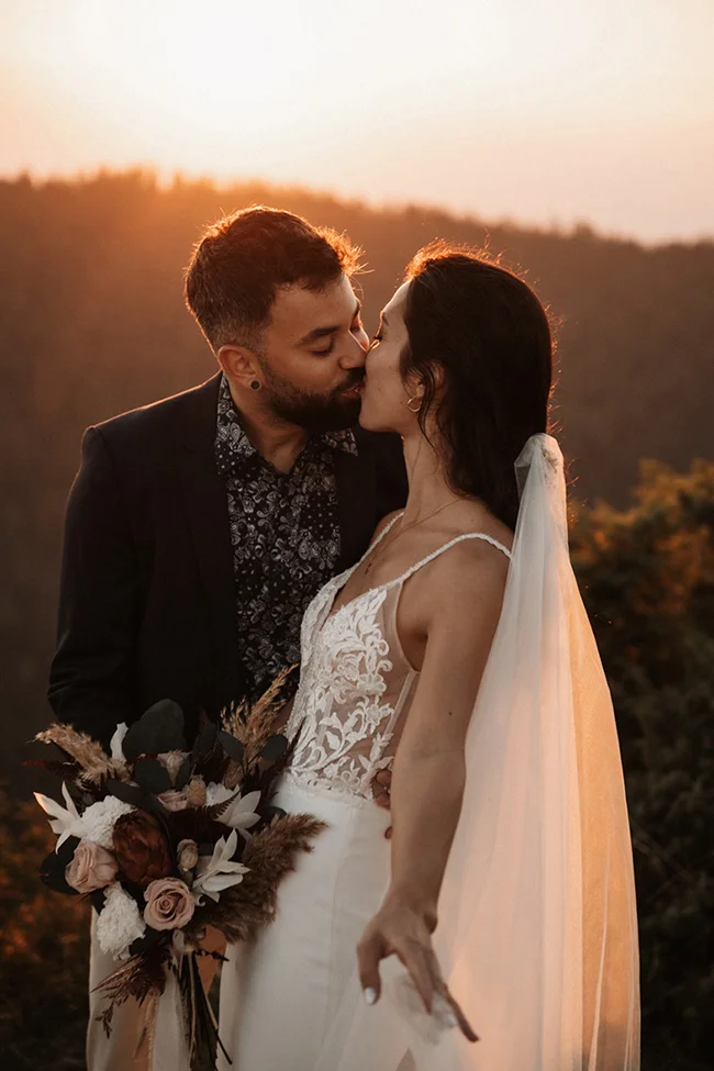 Un couple émerveillé partage un moment romantique au coucher de soleil, entouré des paysages magnifiques du Parc