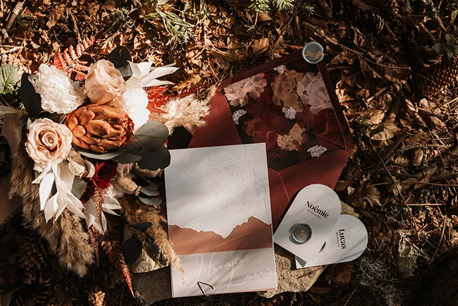 Un bouquet romantique de fleurs artisanales et des invitations élégantes pour un élopement intime au parc national du Vercors.
