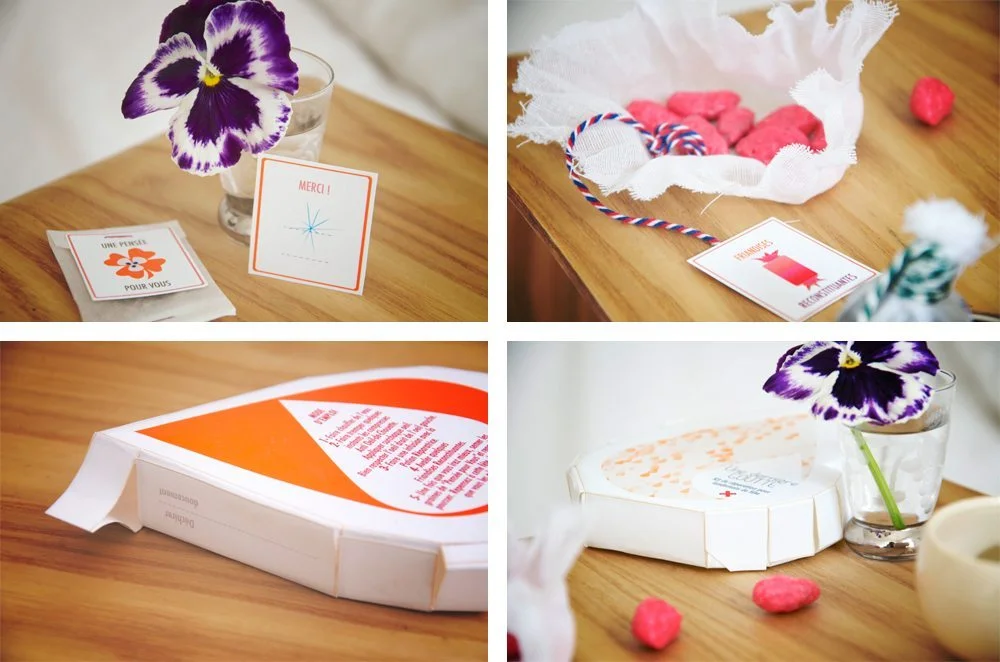 Détails de cadeaux d'invités DIY avec fleurs violettes, douceurs roses et cartes de remerciement sur bois clair.