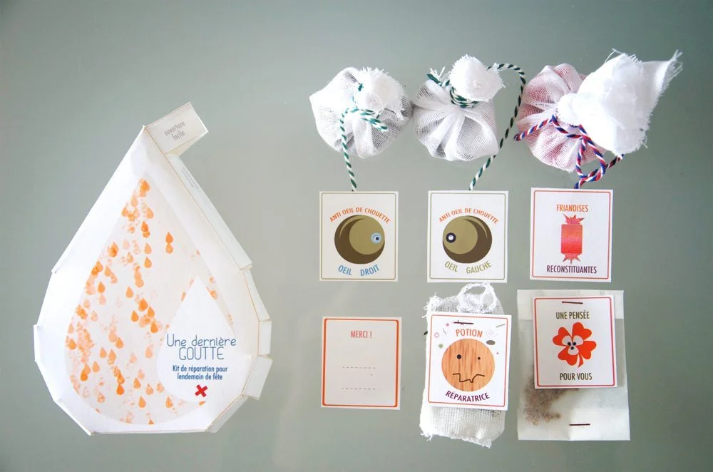 Kit de soin post-fête composé de petits sachets blancs et de cartes illustrées sur un fond gris neutre.