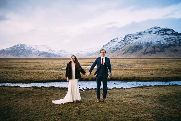 Magique scène romantique avec un couple marié tenant main devant des montagnes glacées et un fleuve fluvial, idéal pour