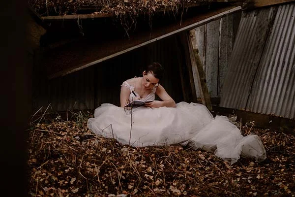 Une mariée en blanc s'adonne à une lecture paisible dans un décor rustique et romantique.