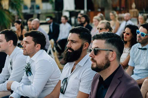Invités élégants assis lors d'une cérémonie de mariage en plein air à Barcelone, ambiance chic et lumineuse.