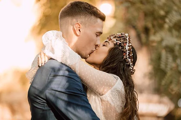 Jeune couple s'embrassant tendrement dans un décor naturel et lumineux, style bohème.