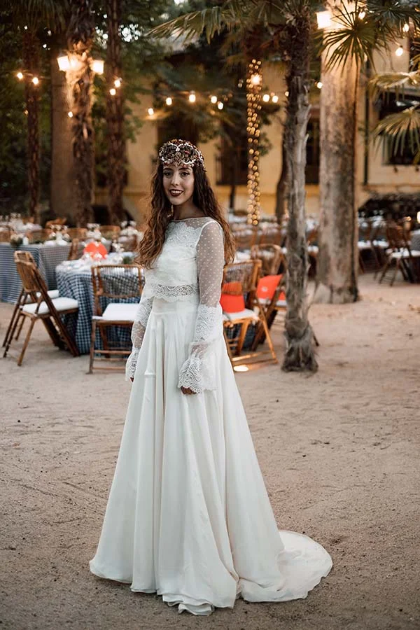 Mariée en robe blanche bohème et couronne de fleurs, posant dans un cadre festif et lumineux à Madrid.