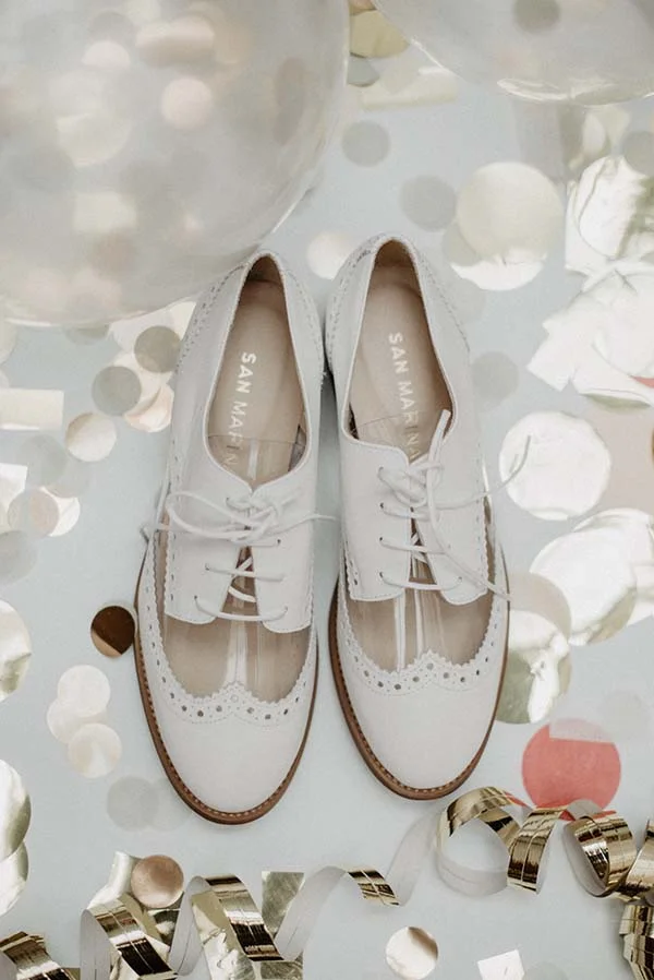Chaussures blanches élégantes avec des motifs perçus, idéales pour un mariage parfait.
