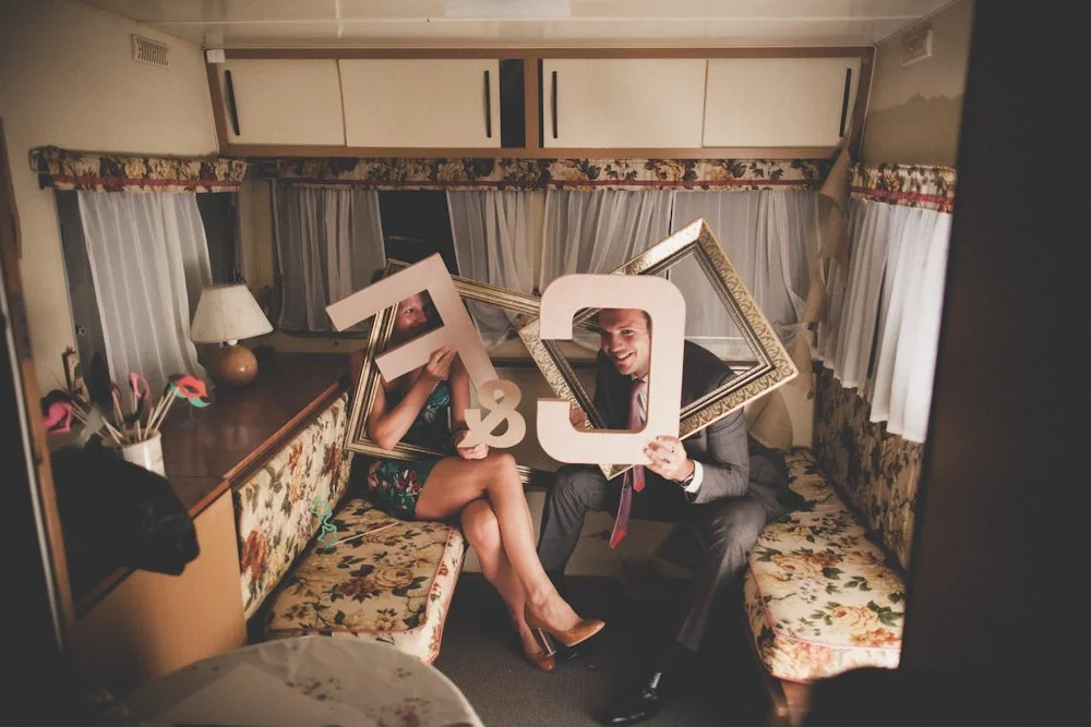 Joyeux couple dans un RV décoré avec des numéros de mariage, partageant un moment de bonheur.