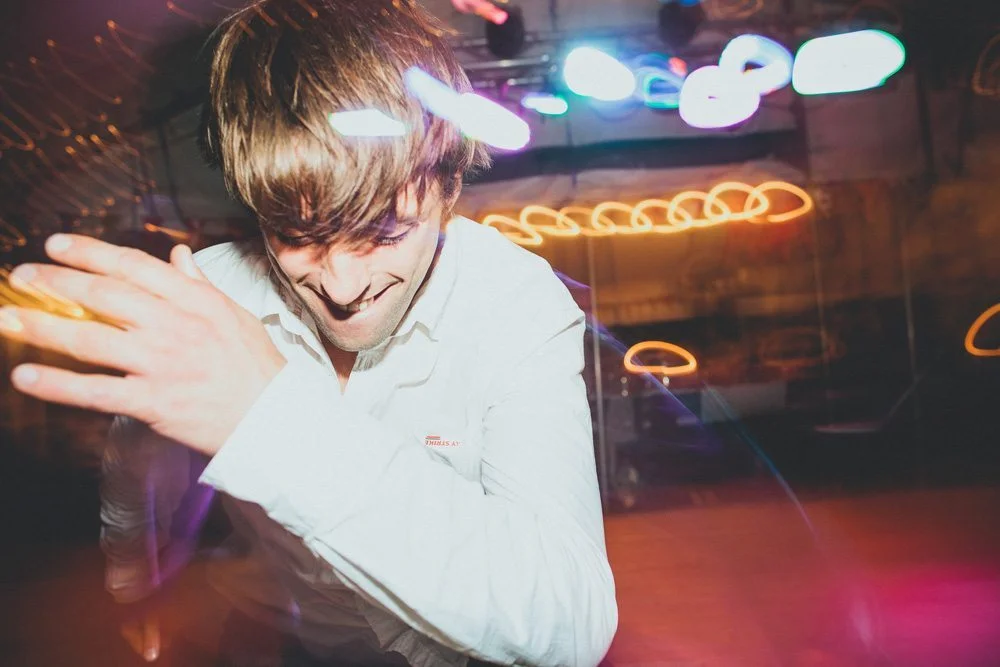 Un jeune homme dans un décor lumineux et coloré, capturant l'essence d'une fête animée et joyeuse.