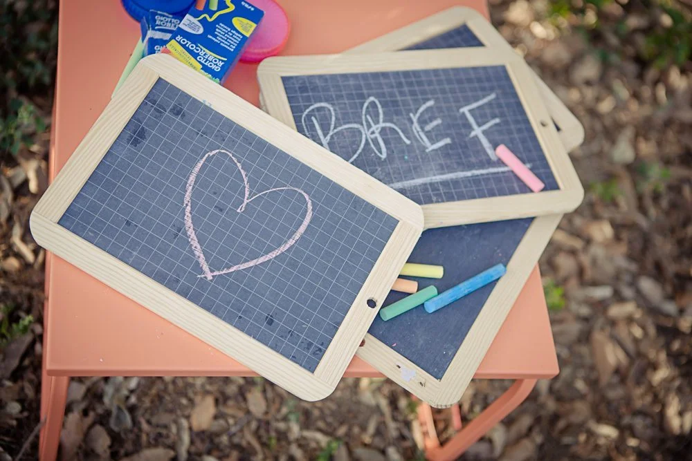 Tableau de béton rose avec des tablettes à table, ornées de cœur et de lettres, pour une ambiance chaleureuse et romantique.