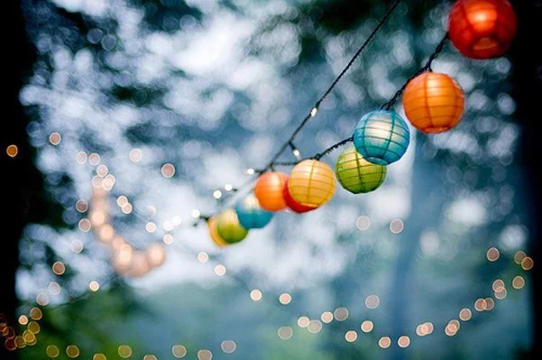 Un décor charmant avec des lumières colorées et des lanternes suspendus, créant une atmosphère magique et joyeuse.