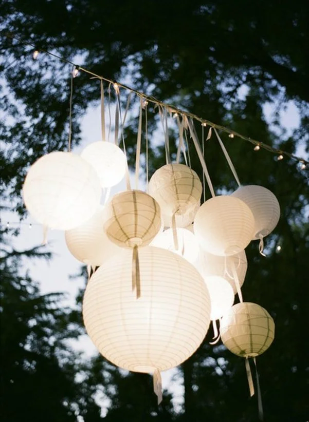 Magnifique suspension de lumières de fête blanche et ronde, créant un ambiance magique et romantique.
