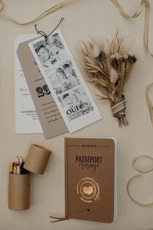 Un ensemble élégant de matériaux de papeterie pour un mariage, avec un focus sur un passeport de mariage et des photos anciennes.
