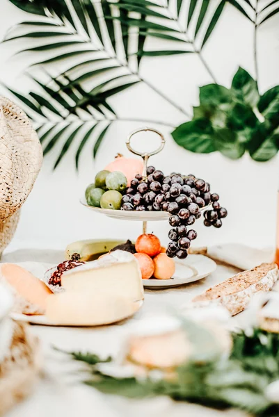 Magnifique décoration de repas de mariage avec fruits frais et fromages, décoré de feuilles palmées et de feuilles vertes.