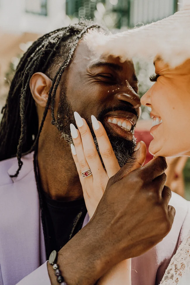 Couple amoureux et souriant s'enlaçant tendrement dans des tons pastel et chaleureux.
