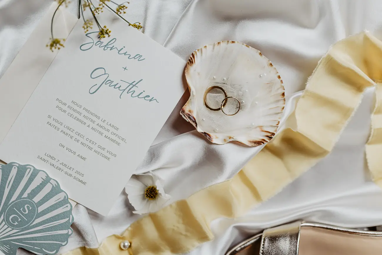 Magnifique scène de mariage avec invitation et anneaux de mariage dans un décor romantique.