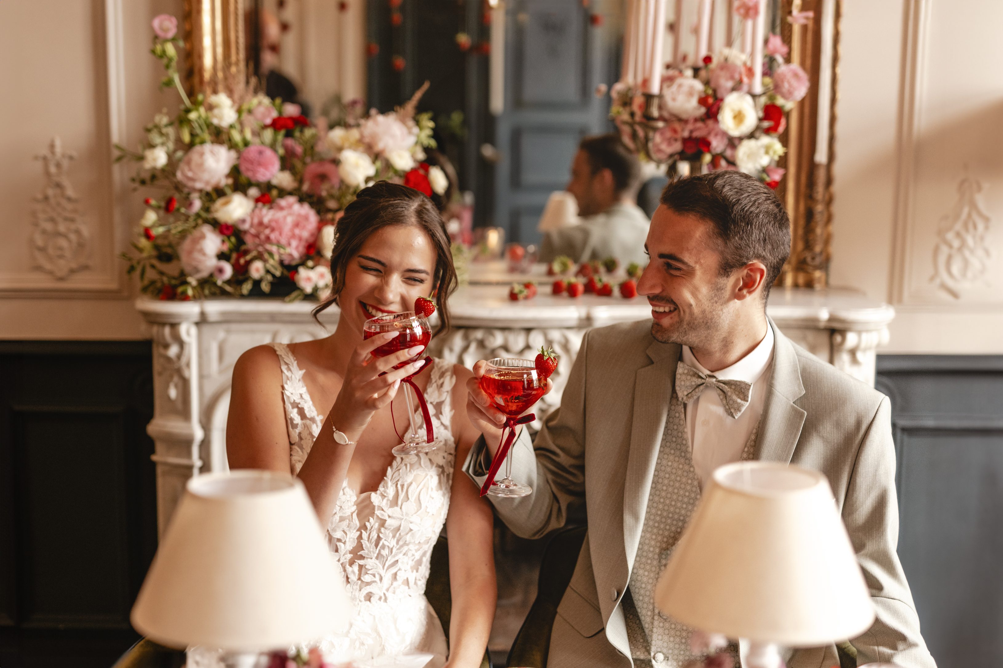 Les deux mariés qui trinquent avec un cocktail dans les tons de la décoration