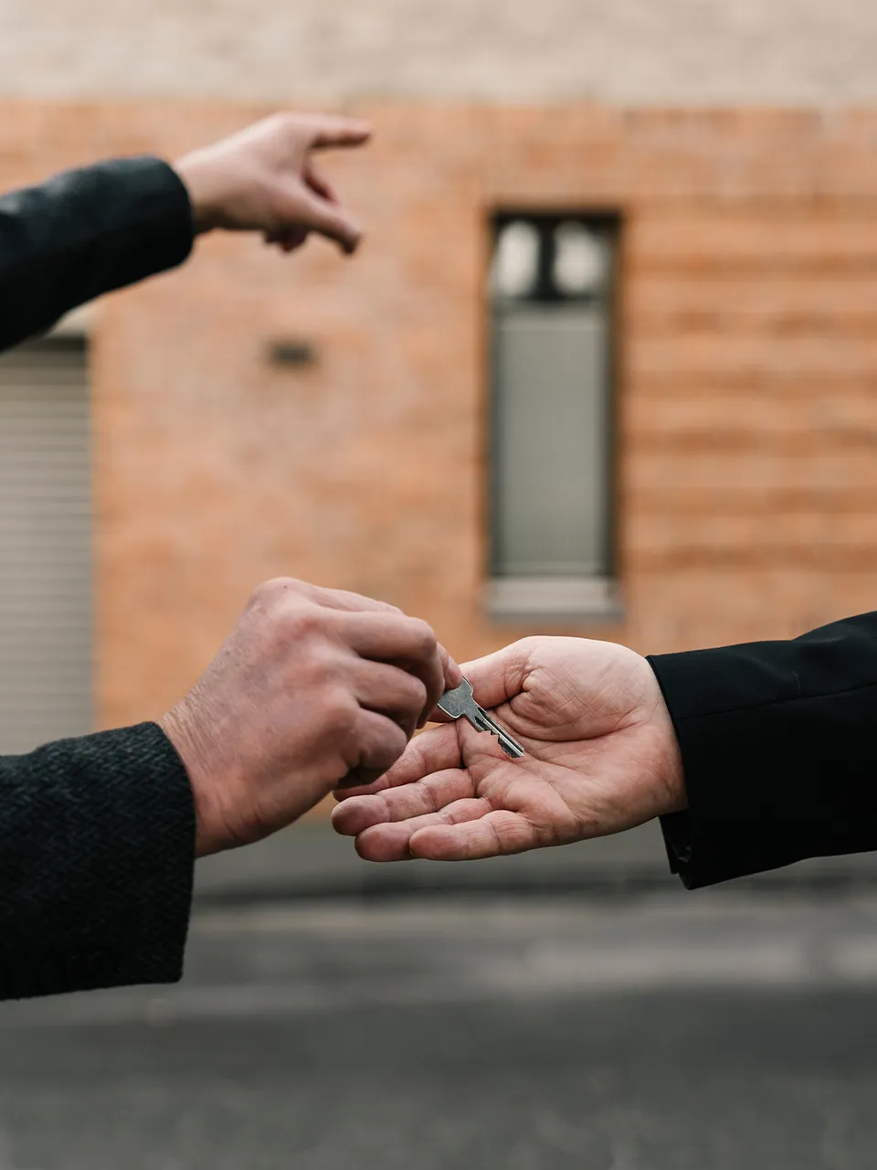 Two people holding keys to each other on a table.