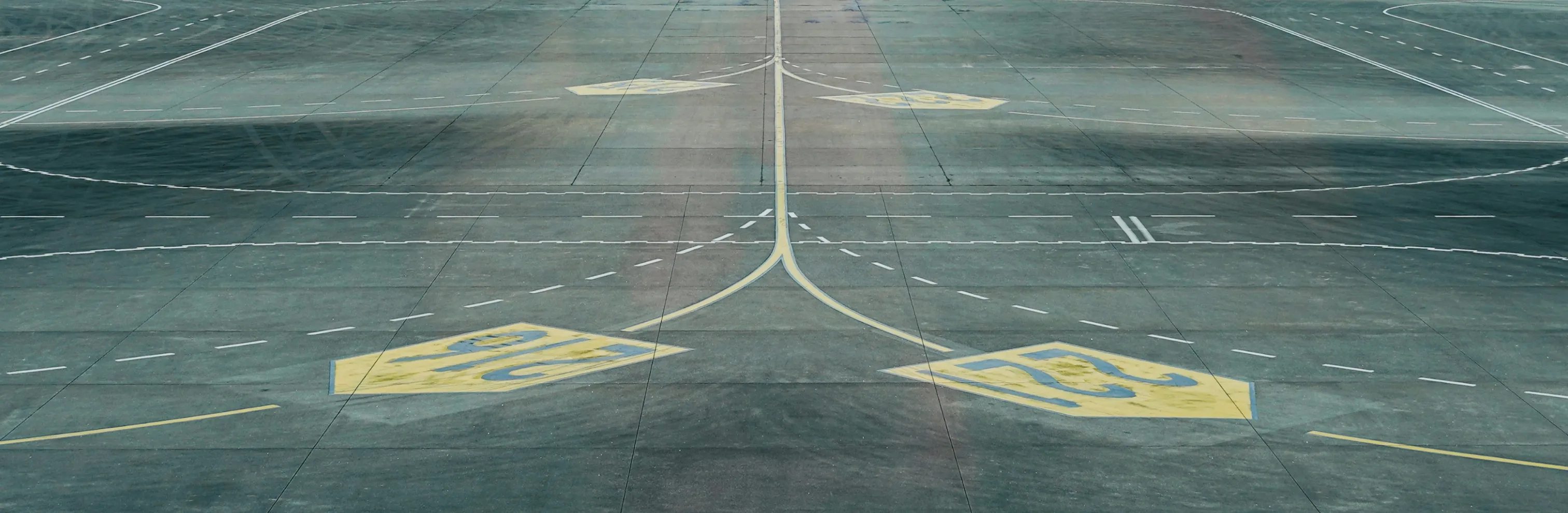 Start- und Landebahn eines Flughafens mit Markierungen und Linien auf dem Asphalt.