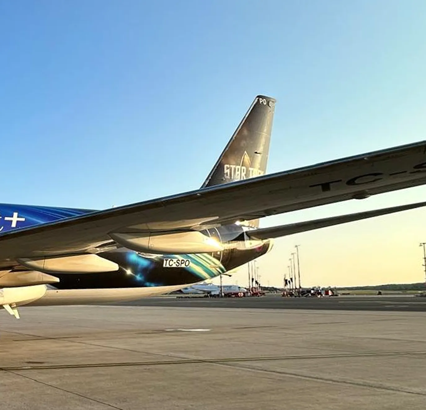 Flugzeug am Rollfeld mit Heckflosse und Flügel in der Abendsonne, Heckflosse zeigt Star Trek Schriftzug.