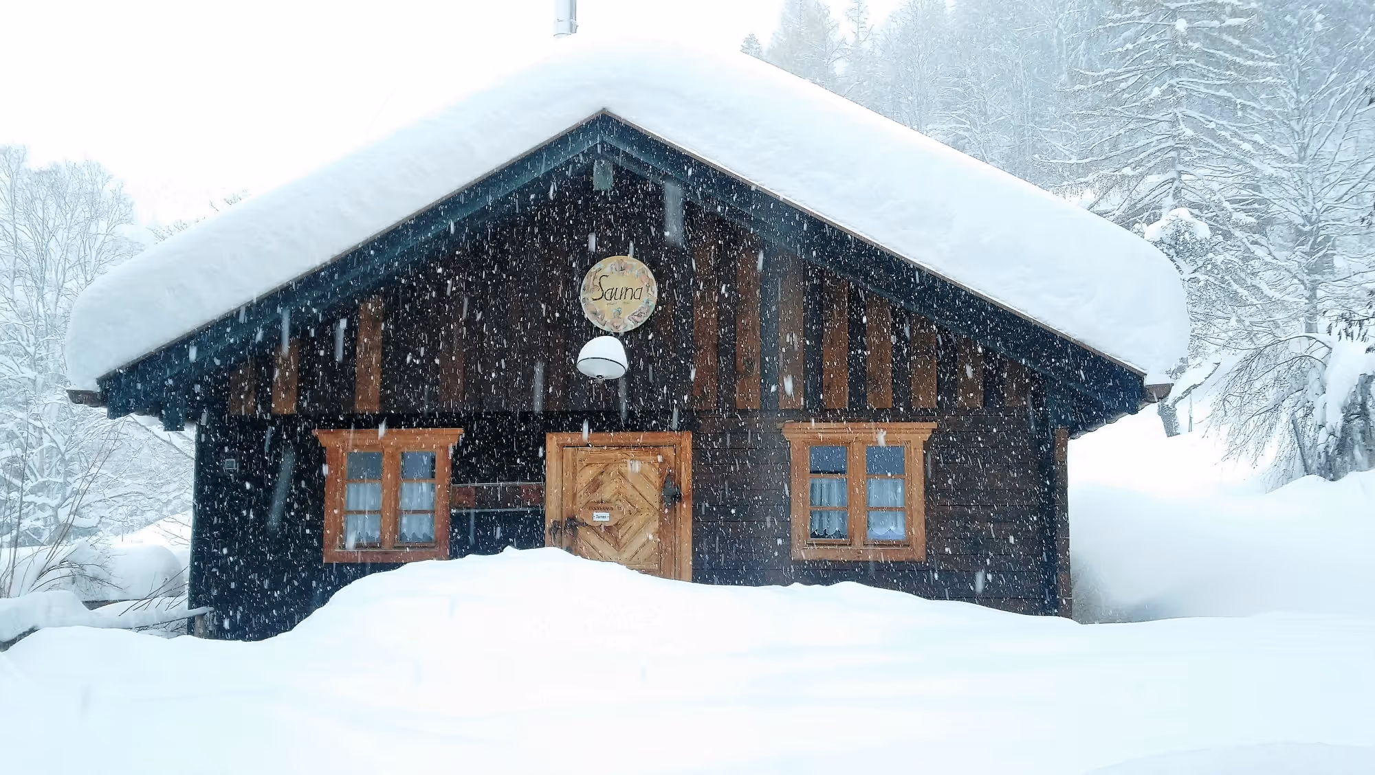 Winterliche Sauna im Schneefall im Naturhotel Tannerhof Bayrischzell