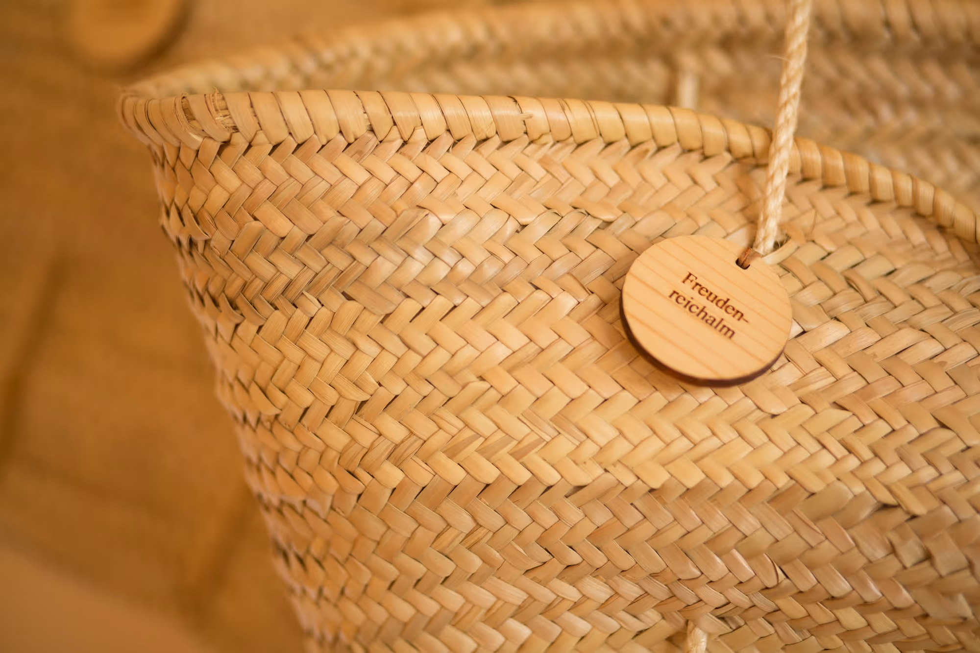 Geflochtener Korb mit handgeschriebenem Holzschild als Detail im Almzimmer des Tannerhof