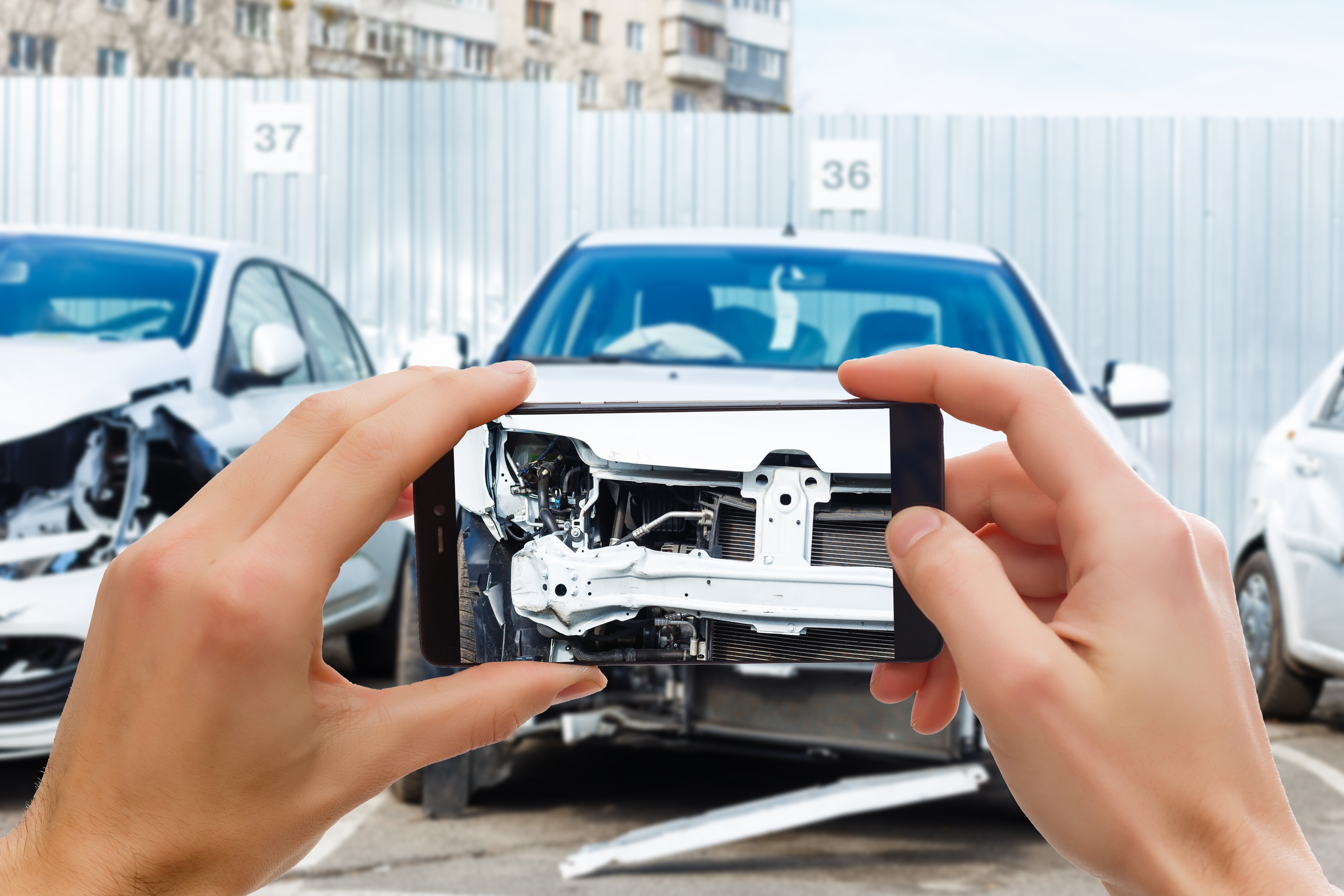 Image of someone capturing photo of a damaged vehicle