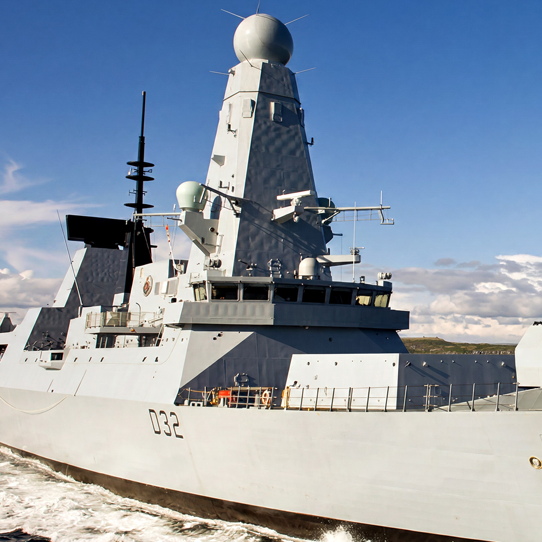 HMS Daring naval destroyer sailing at sea under clear skies.