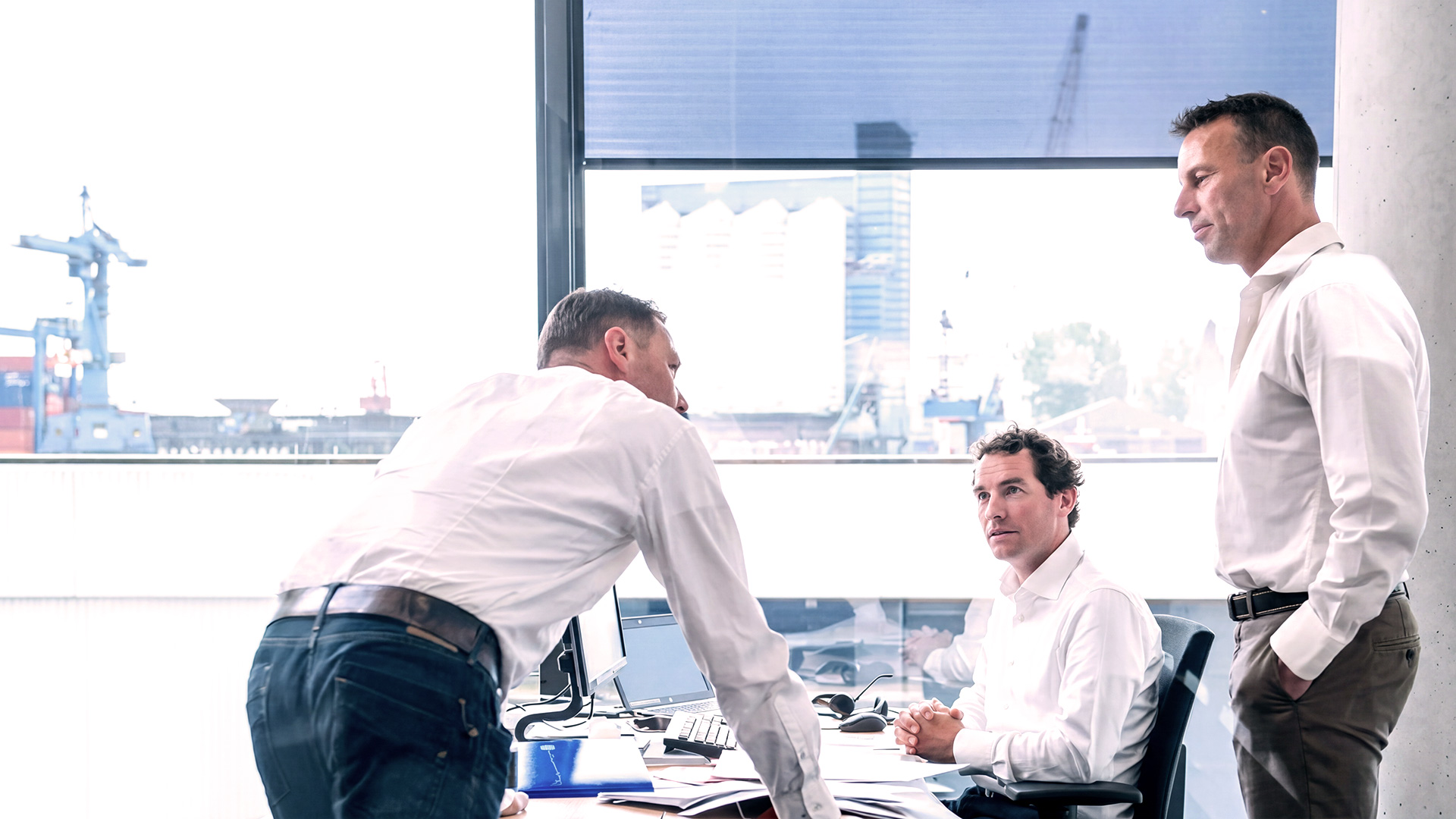 Marine lifecycle solutions team discussing operational benefits and long-term fleet support in an office environment.