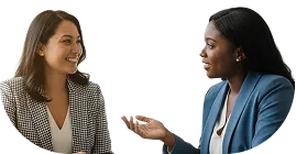 Two professional women smiling and having a conversation while seated.