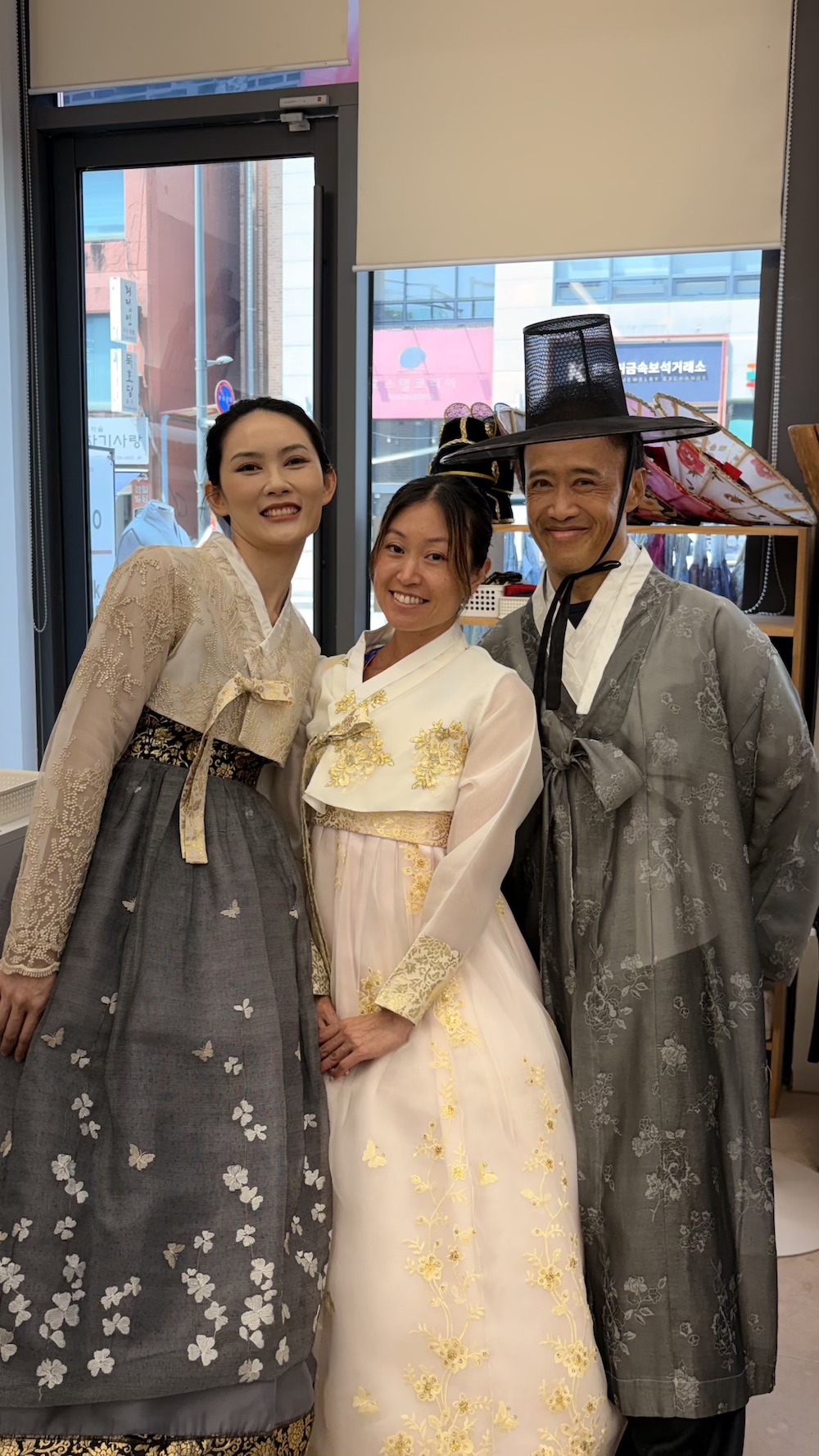 Phyllis, Teny, and Ray posing in traditional Korean Hanbok outfits.
