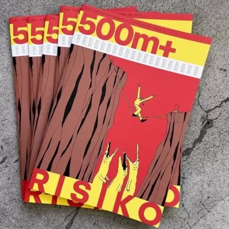Das Bild zeigt einen gestapelten Stapel von Magazinen mit dem Titel „500m+“, der prominent auf dem Titelblatt in weisser Schrift auf einem roten und gelben Hintergrund zu sehen ist. Es handelt sich um die Ausgabe Nr. 4 / 2025 des Magazins. Das auffällige Cover-Design zeigt eine Illustration zweier senkrechter Felswände mit einer tiefen Schlucht dazwischen. Eine Person in gelber Kleidung balanciert auf einem Seil zwischen den beiden Felsen, während sie von einer Sicherheitsleine gesichert ist. Unter ihr reissen drei stilisierte Krokodile oder Raubtiere mit weit geöffneten Mäulern ihre Arme in die Höhe – eine Darstellung von Gefahr und Risiko. Am unteren Rand des Covers steht in grossen, fetten, roten Buchstaben auf gelbem Grund das Wort „RISIKO“. Die Szene symbolisiert den Umgang mit Gefahr und Unsicherheit, wahrscheinlich als zentrales Thema der Ausgabe. Im Hintergrund befinden sich verschwommen erkennbare Büroarbeitsplätze mit Monitoren, Tastaturen und Notizbüchern auf hellen Holztischen.