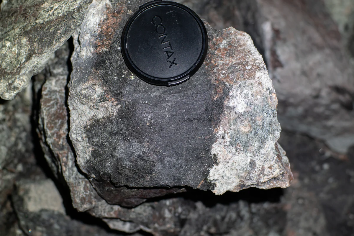 Steinprobe aus dem Bergwerk Kiruna: Das Dunkle ist Eisenerz, direkt daneben das helle Tongestein Bentonit.