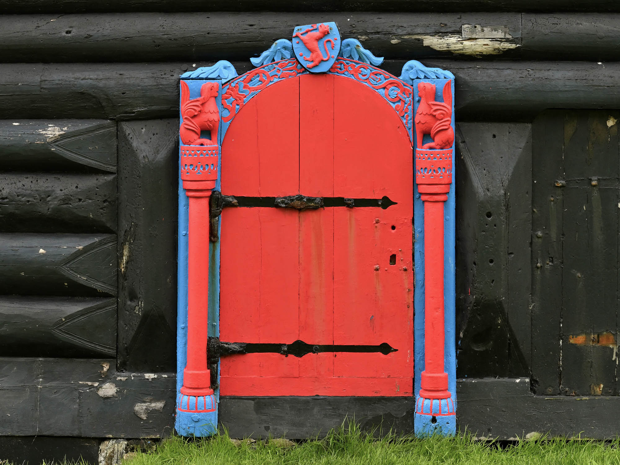 A traditional turf-roofed Faroese farmhouse with red-framed windows overlooking the Atlantic