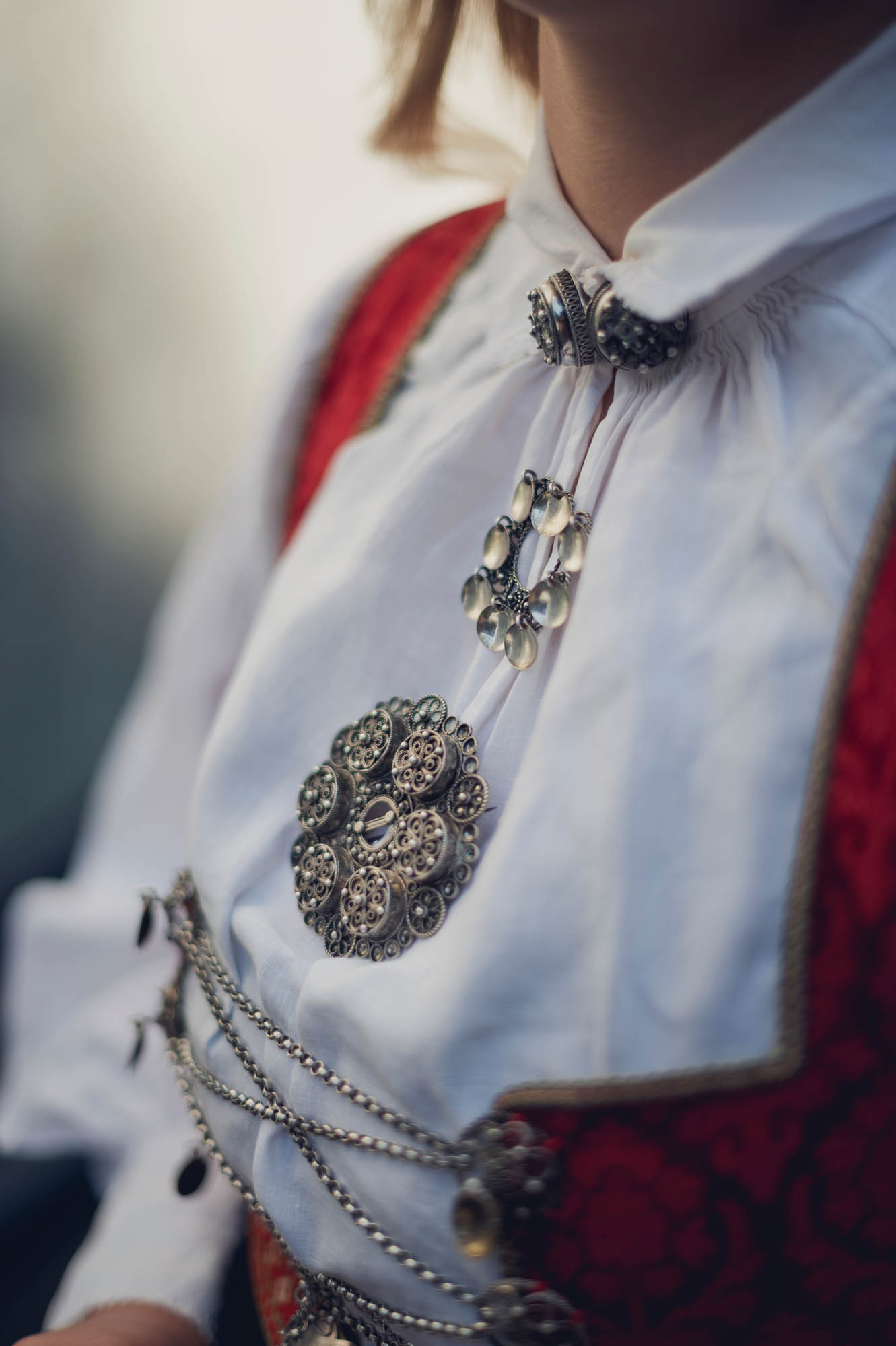 Close-up of intricate silver sølje brooches adorning a traditional Norwegian bunad — a symbol of Nordic cultural heritage