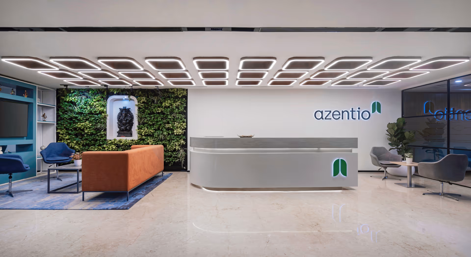 Modern reception desk with computer in a minimalist office space featuring dark walls and large window.