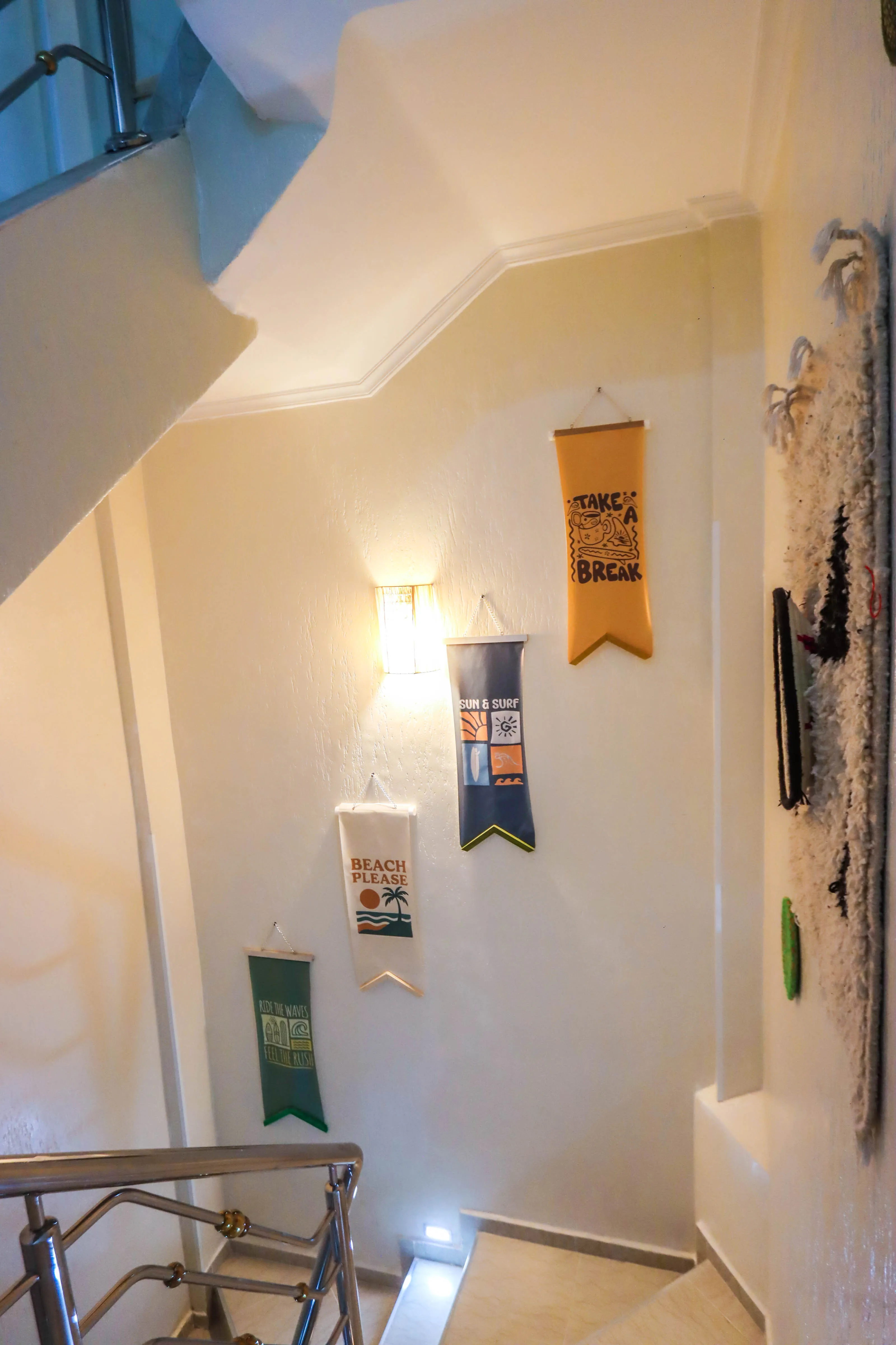 Staircase wall with four colorful hanging banners featuring beach and surf themes.