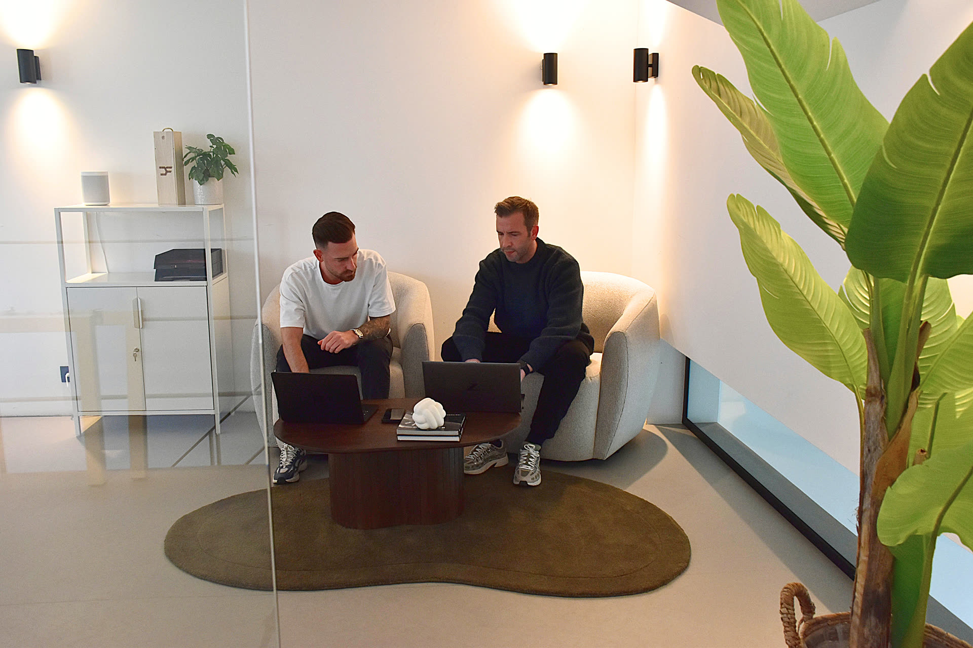 Olivier en Bryan bespreken klantencampagnes in de zithoek van DeFacto