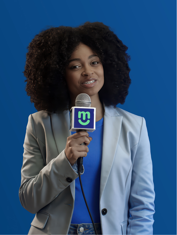 Presentadora sonriente con cabello rizado sostiene un micrófono frente a fondo azul.