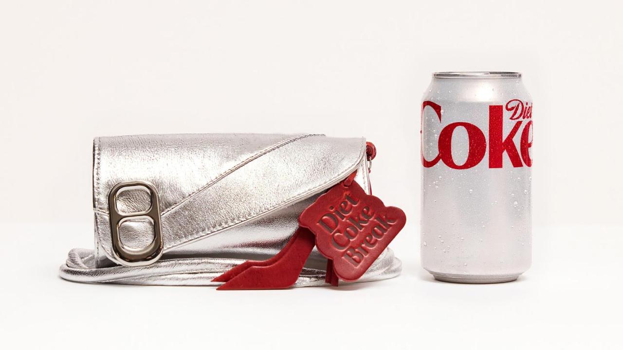 Bolso plateado con etiqueta roja que dice Diet Coke Break junto a una lata de Diet Coke.
