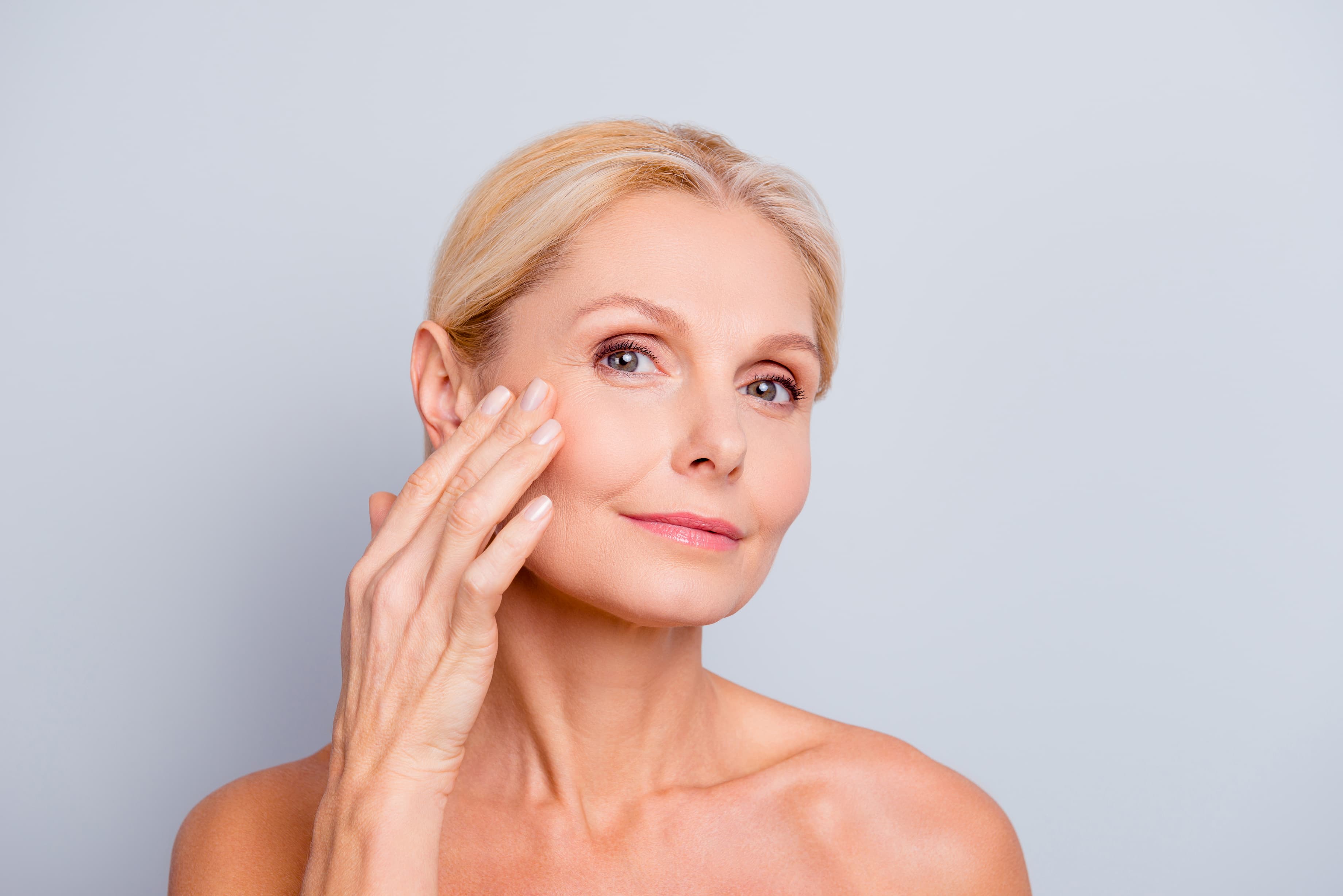 A woman holding her hand up to her face.