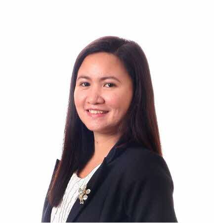 Smiling woman with long dark hair wearing a black blazer and white top against a white background.