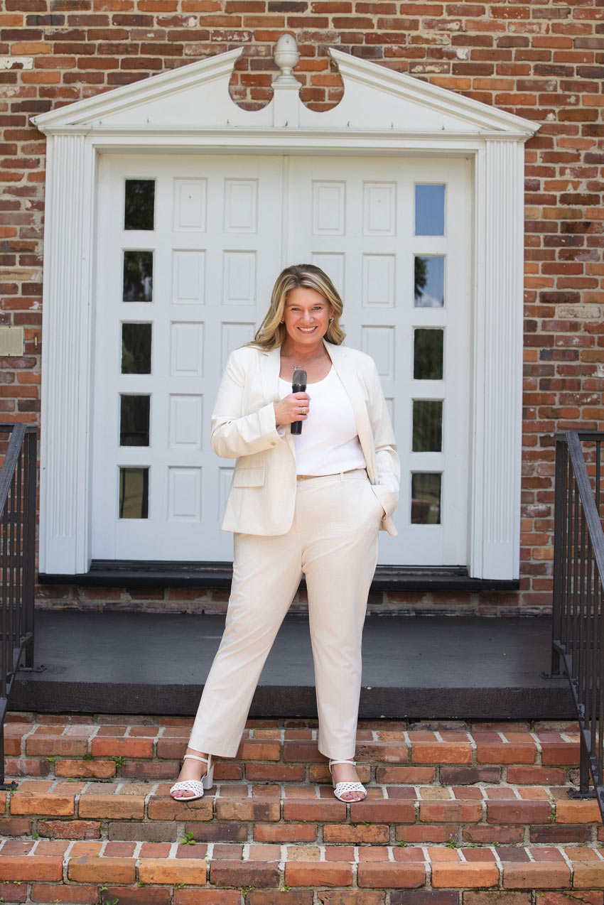 Tamiko McGurk holding a microphone outside a brick building