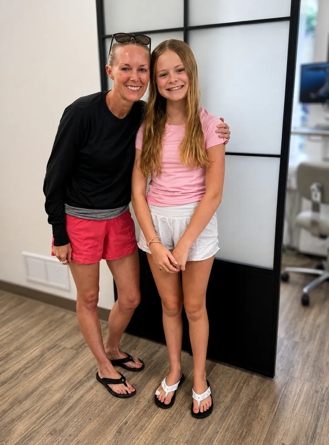 A mother and daughter smiling in the Darien Orthodontics office