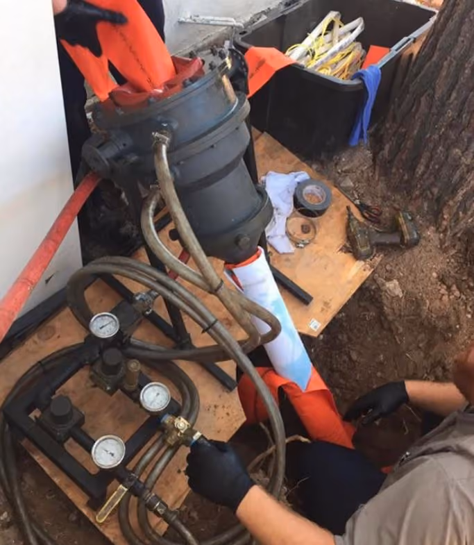 Sump pump repair services in Tucson AZ - technician servicing sump pump with pressure gauge monitoring and replacement parts