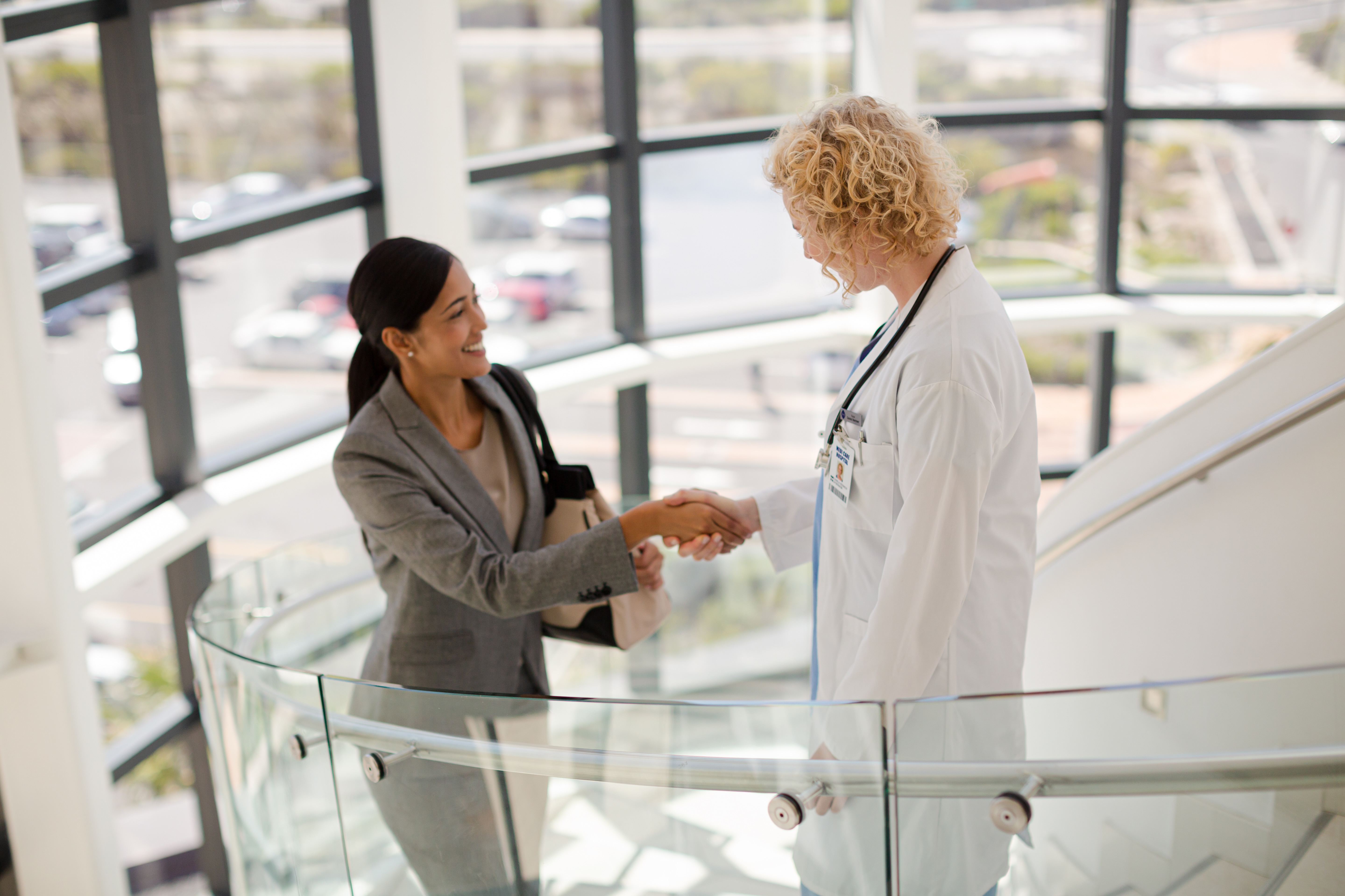 Business woman and doctor shaking hands stock photo