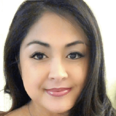 Portrait of a woman with dark hair and a slight smile facing the camera