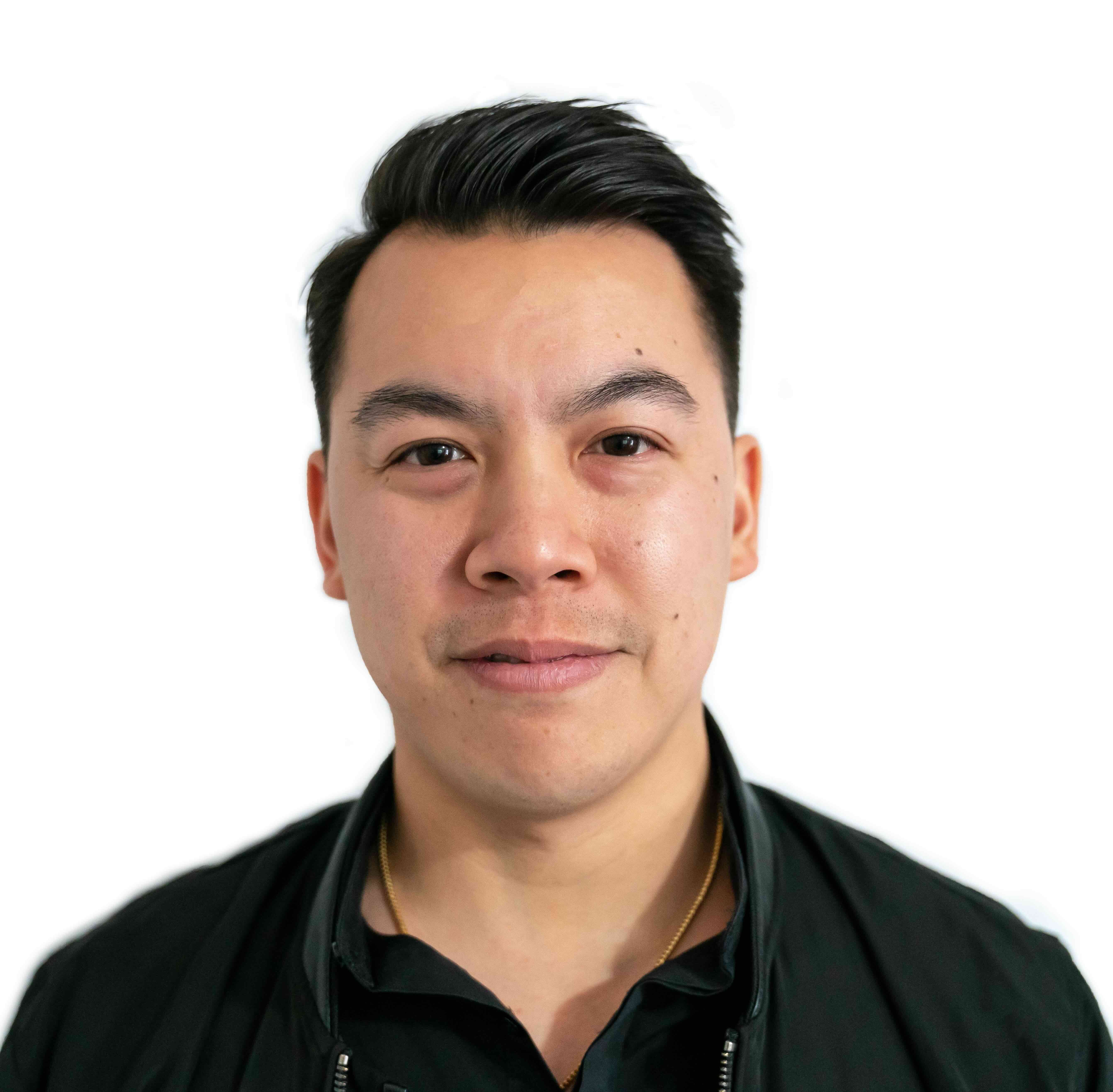 Portrait of an Asian man with dark hair wearing a black jacket against white background